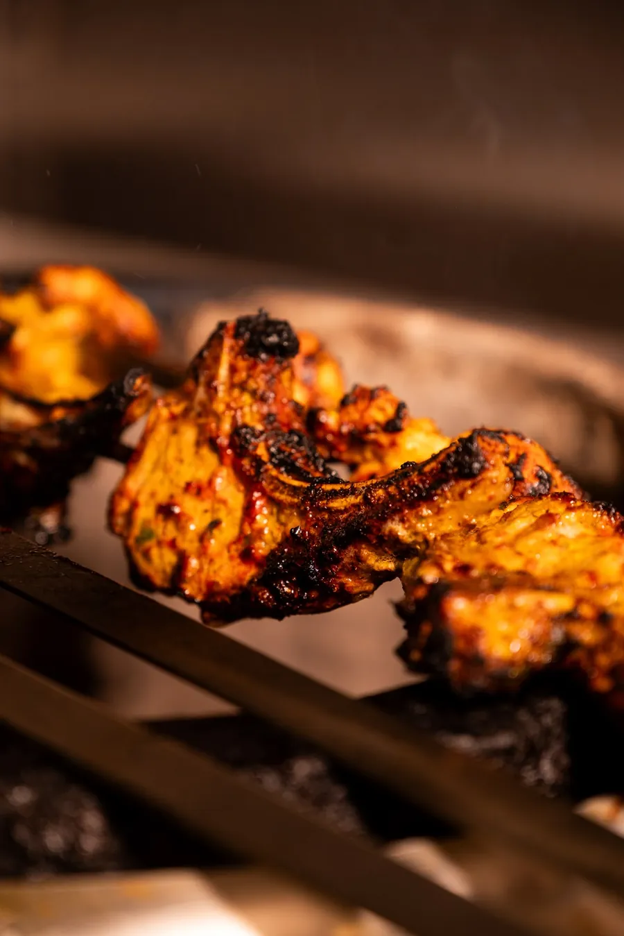 Charred tandoori chicken over the coals